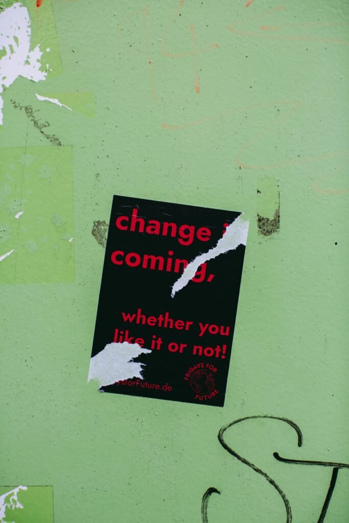 A green wall with black torn paper stick to it. The black paper has text in red.